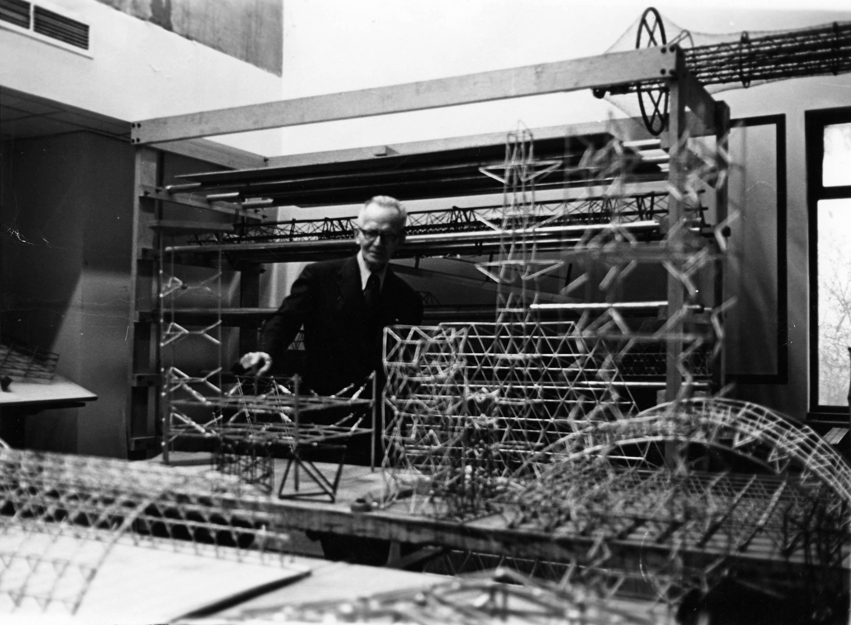 Robert Le Ricolais posant derrière ses maquettes. Cl. anonyme. Nd © Fonds de la revue Architecture d’aujourd'hui. SIAF/CAPa/Archives d’architecture du XXe siècle. 203 Ifa